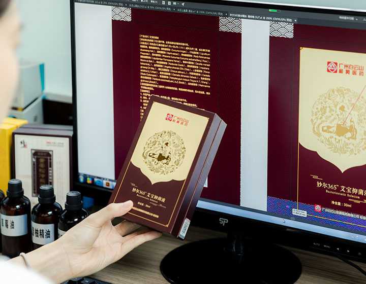 a staff designing essential oil packaging on the computer